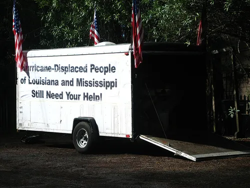 Trailer with flags and a sign asking for help for hurricane-displaced people of Louisiana and Mississippi